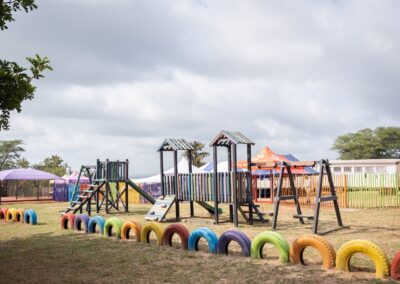 Colorful playground with climbing frames, swings, and painted tires at Makwetse Primary School.