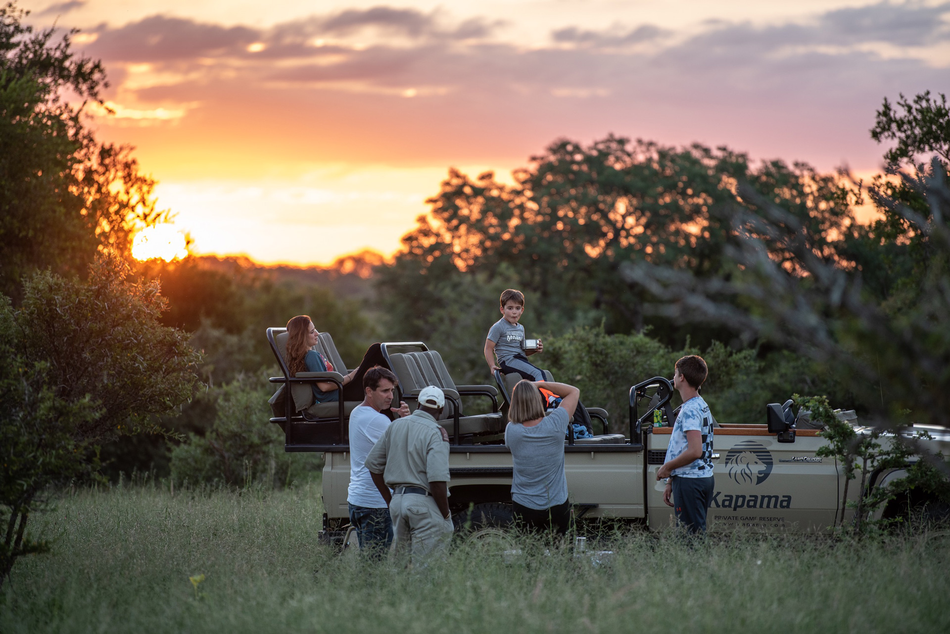 Family enjoying a sunset game drive at Kapama Private Game Reserve.