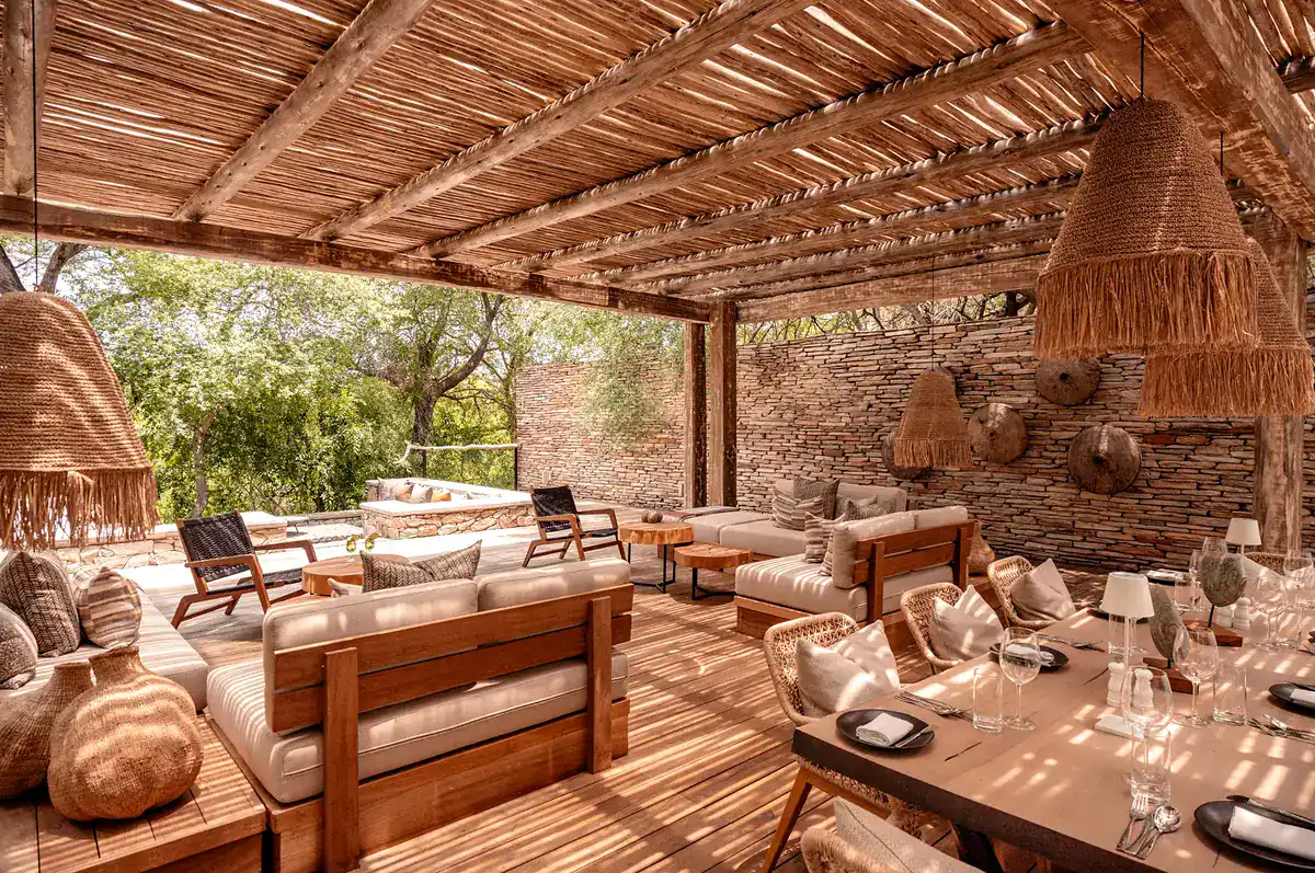 Shaded outdoor lounge and dining deck at Kapama Karula
